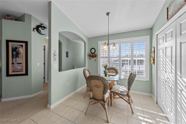 dining space featuring light tile patterned floors and vaulted ceiling