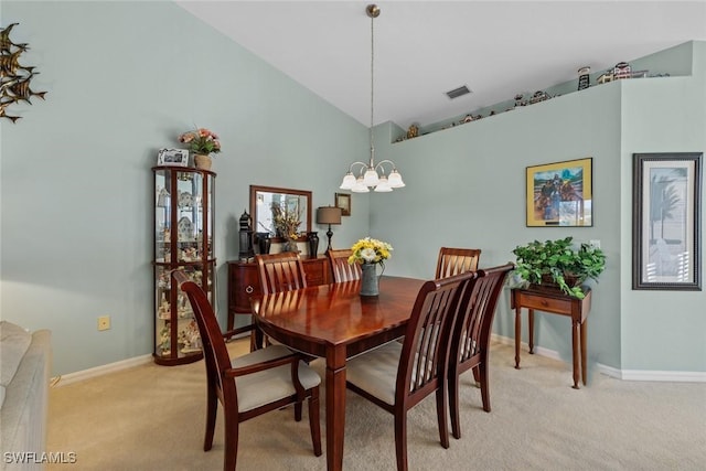 carpeted dining space featuring an inviting chandelier and high vaulted ceiling