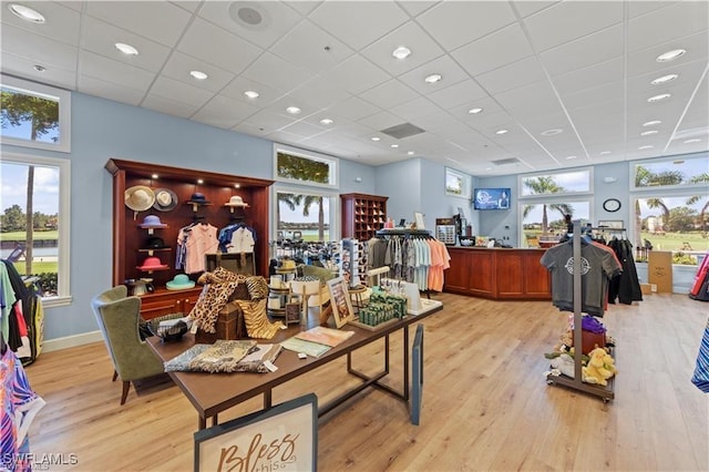 interior space with a drop ceiling and light hardwood / wood-style floors