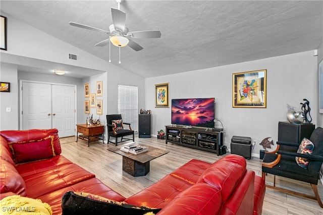 living room featuring vaulted ceiling, ceiling fan, hardwood / wood-style floors, and a textured ceiling