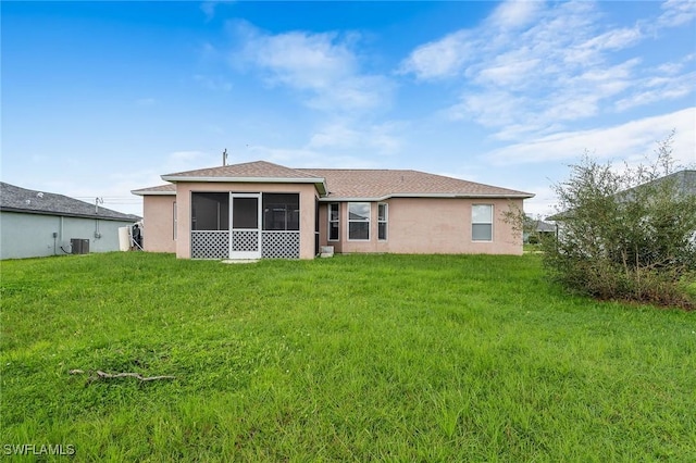 rear view of property featuring cooling unit and a lawn