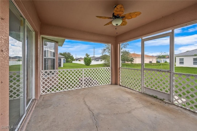 unfurnished sunroom with ceiling fan