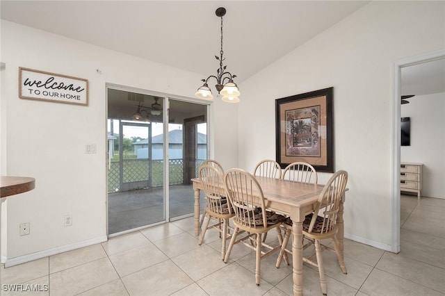 dining area with baseboards, light tile patterned flooring, and vaulted ceiling