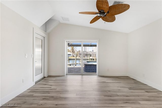 unfurnished room featuring ceiling fan, lofted ceiling, and light hardwood / wood-style flooring