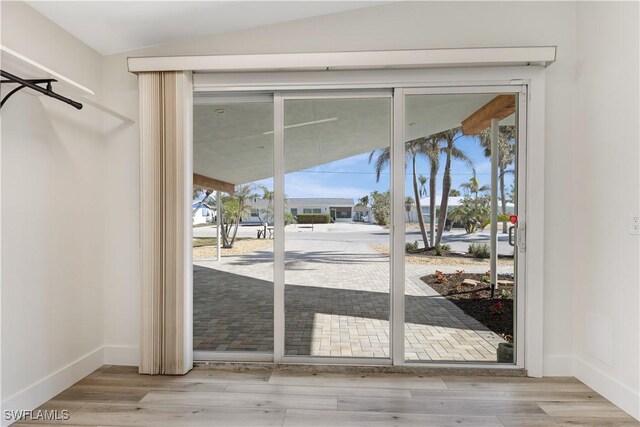 entryway featuring lofted ceiling and light hardwood / wood-style flooring