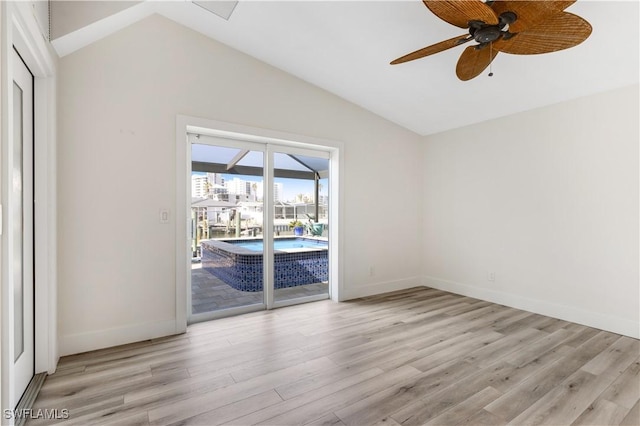 spare room featuring light hardwood / wood-style flooring, vaulted ceiling, and ceiling fan