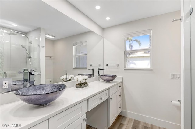 bathroom with vanity, hardwood / wood-style flooring, a shower with door, and toilet