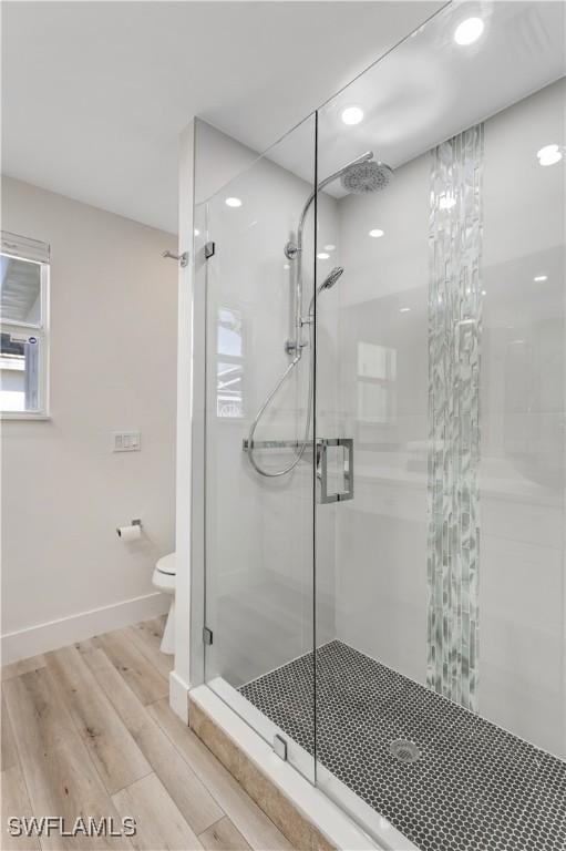 bathroom with an enclosed shower, hardwood / wood-style flooring, and toilet