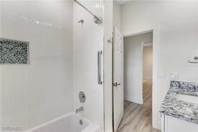 bathroom featuring vanity, hardwood / wood-style floors, and tiled shower / bath combo