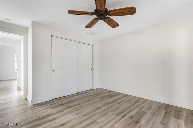 unfurnished bedroom with ceiling fan, light hardwood / wood-style floors, and a closet