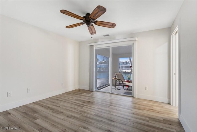 spare room with ceiling fan and light wood-type flooring