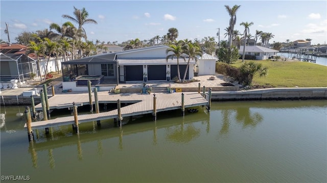 dock area featuring a water view, a hot tub, and a lawn