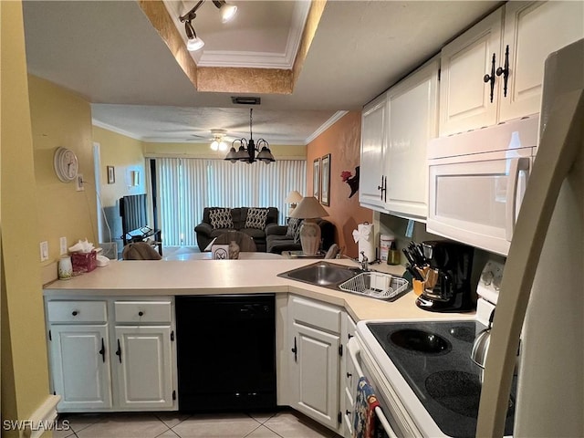 kitchen with a tray ceiling, ornamental molding, a sink, white appliances, and a peninsula