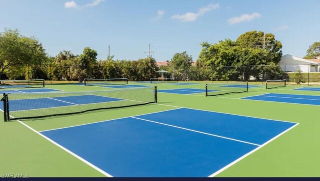 view of tennis court featuring community basketball court and fence