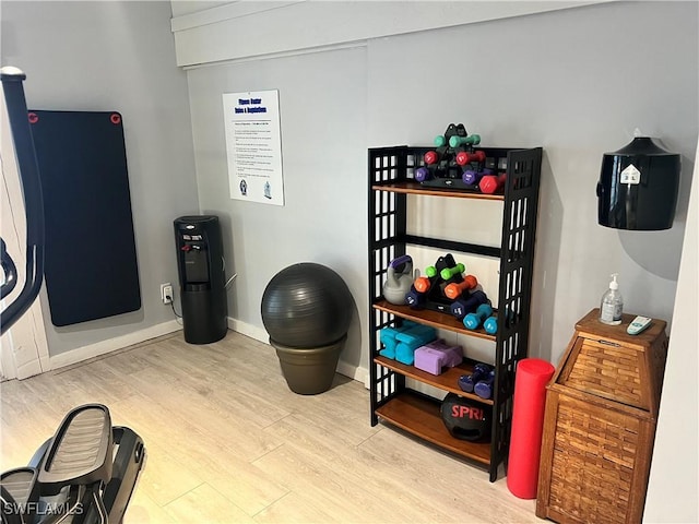 workout area featuring baseboards and wood finished floors