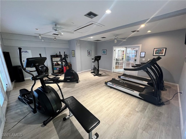 exercise room with baseboards, light wood-type flooring, visible vents, and a ceiling fan