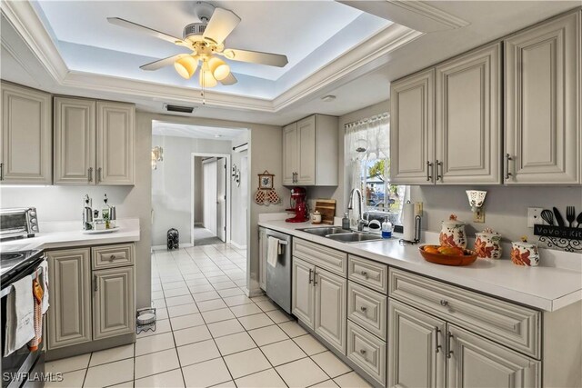 kitchen featuring sink, light tile patterned floors, stainless steel appliances, and a raised ceiling