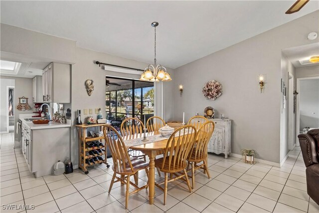 tiled dining space with sink and a notable chandelier