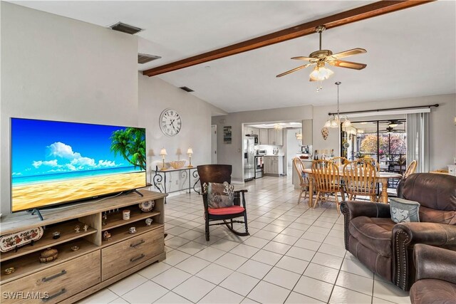 tiled living room featuring lofted ceiling with beams and ceiling fan with notable chandelier