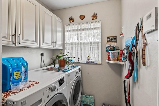 washroom featuring washer and clothes dryer and cabinet space