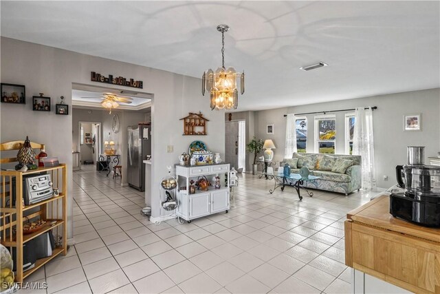 tiled living room with a notable chandelier