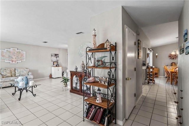 hall featuring light tile patterned floors and baseboards