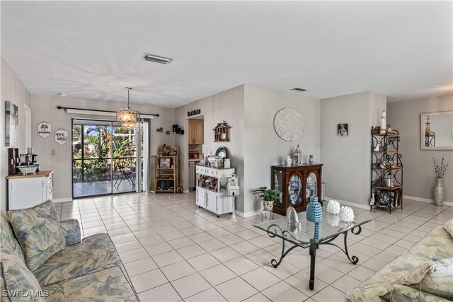 living area featuring a chandelier, visible vents, baseboards, and light tile patterned floors