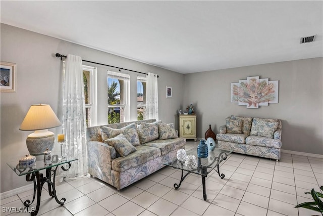 living area featuring light tile patterned floors, visible vents, and baseboards