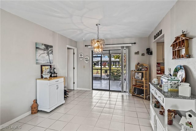 interior space featuring a notable chandelier, baseboards, and light tile patterned floors