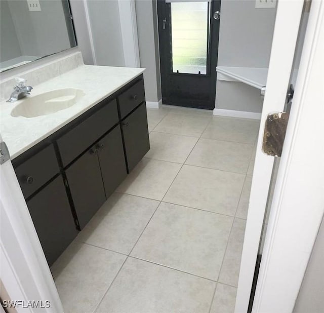 bathroom featuring vanity, baseboards, and tile patterned floors