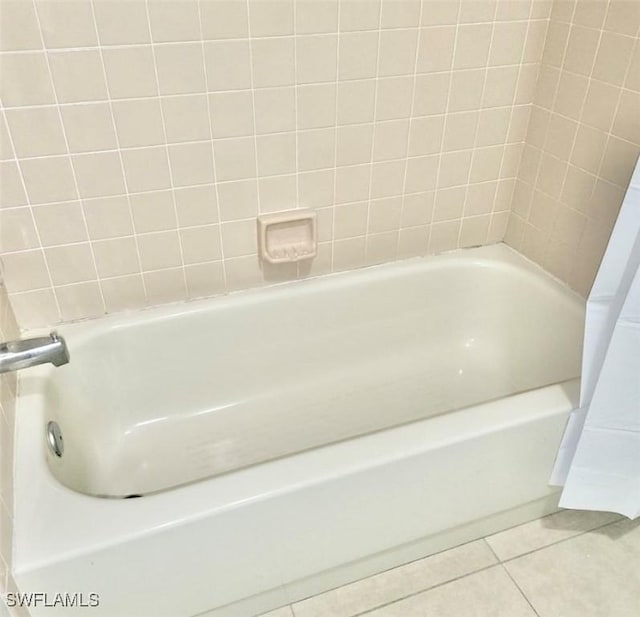 bathroom with a tub and tile patterned floors