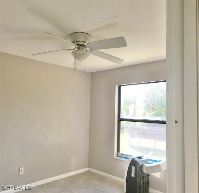 empty room featuring ceiling fan and baseboards