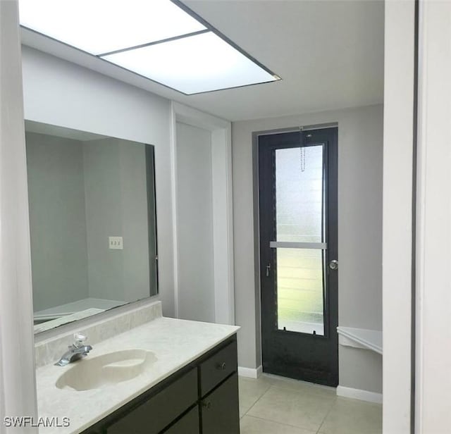 bathroom featuring tile patterned flooring, baseboards, and vanity