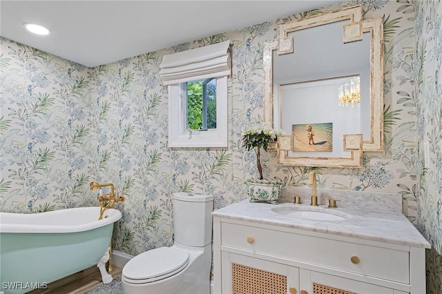 bathroom with vanity, a bathtub, and toilet