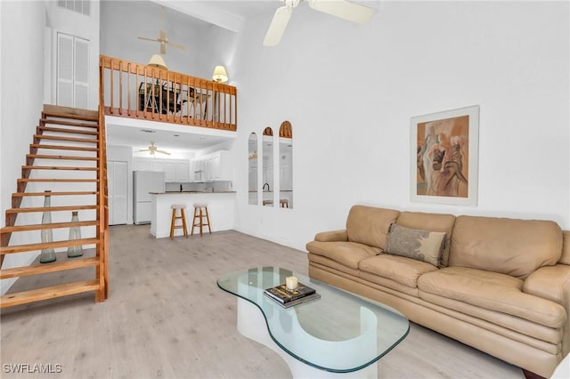 living room with ceiling fan and a high ceiling