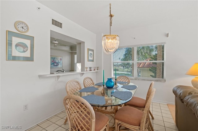 dining area with baseboards, light tile patterned flooring, visible vents, and a notable chandelier