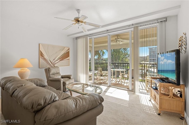 carpeted living area with a wall of windows and a ceiling fan