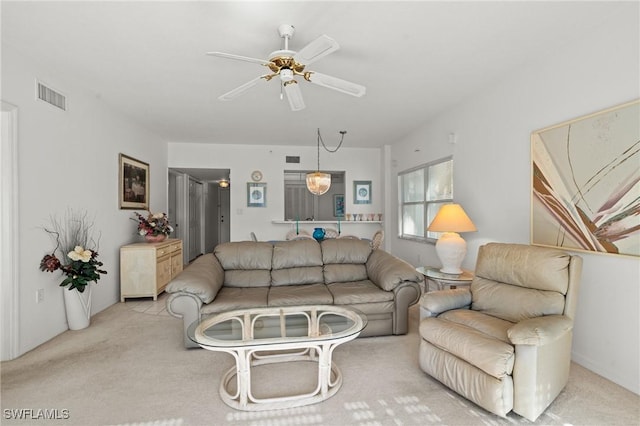 living area featuring light carpet, visible vents, and a ceiling fan