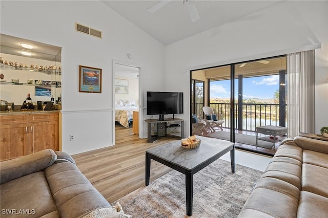 living room featuring high vaulted ceiling, light hardwood / wood-style floors, and ceiling fan