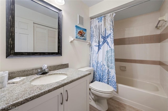 full bathroom with hardwood / wood-style flooring, vanity, shower / bathtub combination with curtain, and toilet