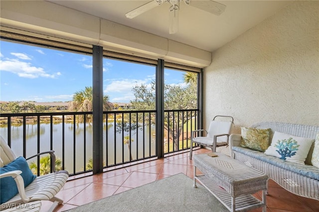 sunroom featuring a water view and ceiling fan