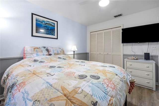 bedroom with wood-type flooring, ceiling fan, and a closet