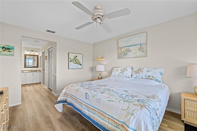 bedroom featuring connected bathroom, light hardwood / wood-style flooring, a closet, and ceiling fan