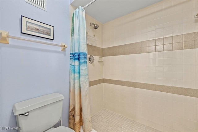 bathroom featuring toilet and curtained shower