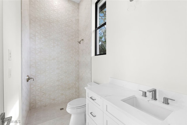 bathroom featuring tile patterned floors, vanity, toilet, and a shower