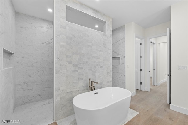 bathroom with wood-type flooring, independent shower and bath, and tile walls