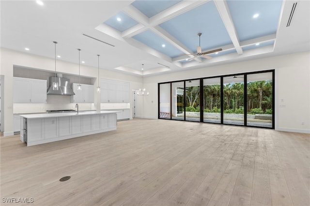 unfurnished living room featuring sink, light hardwood / wood-style flooring, ceiling fan, beam ceiling, and coffered ceiling