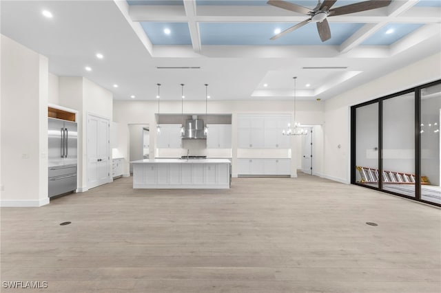 unfurnished living room featuring ceiling fan with notable chandelier, coffered ceiling, light hardwood / wood-style floors, and beamed ceiling