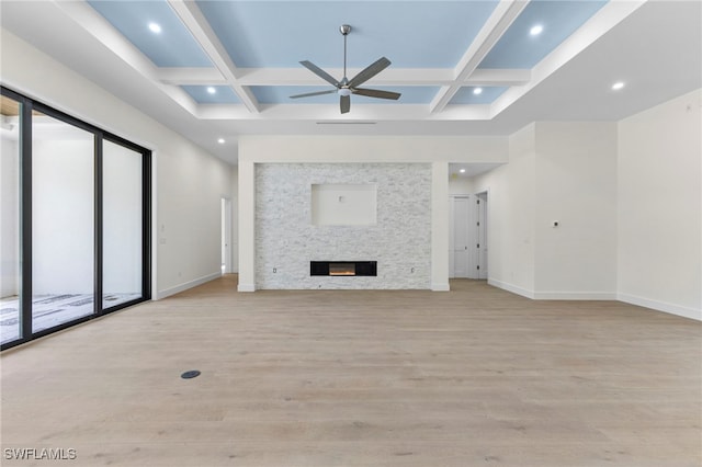 unfurnished living room featuring a fireplace, coffered ceiling, ceiling fan, light hardwood / wood-style floors, and beam ceiling