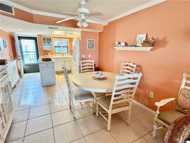 dining area with light tile patterned floors, ornamental molding, sink, and ceiling fan